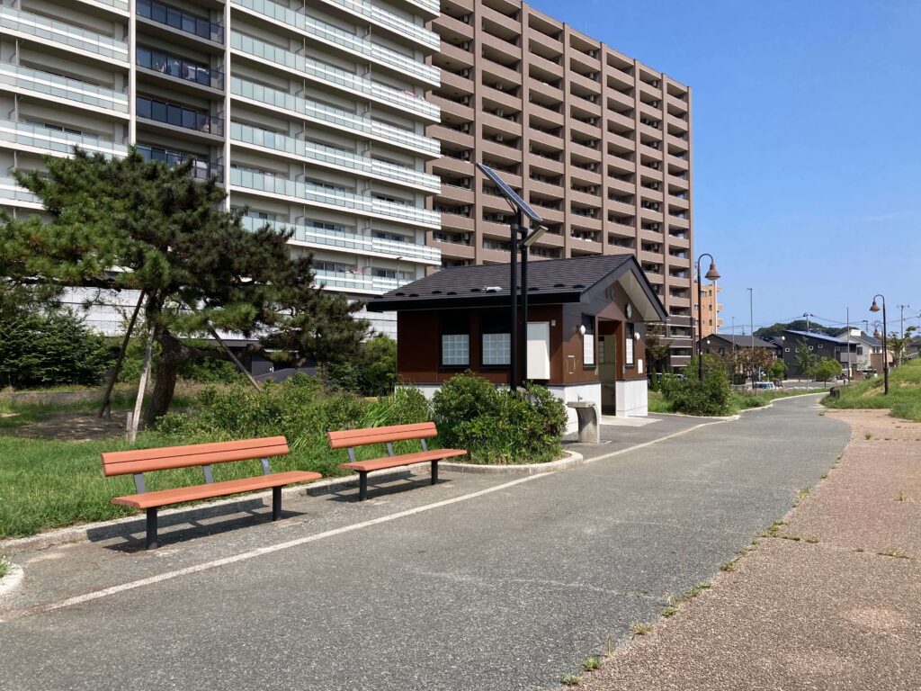 公衆トイレと手洗い場とベンチの写真